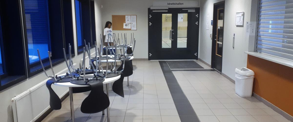 Inngangsparti med kiosk og rom for vakt. Foto: Gode idrettsanlegg Inngangsparti med kiosk, sitteplasser og bord.