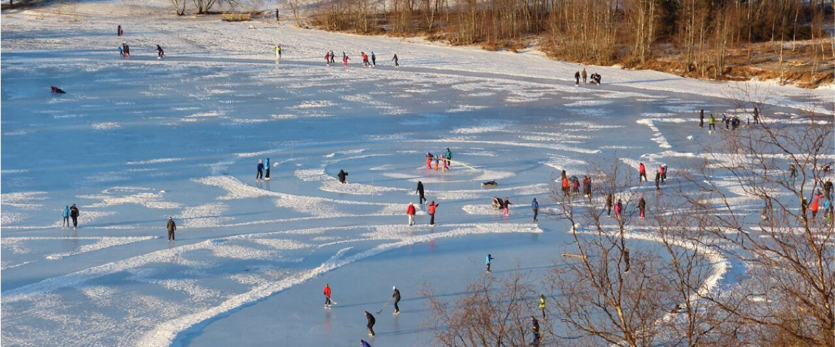 Stor aktivitet på naturisbane en solrik vinterdag