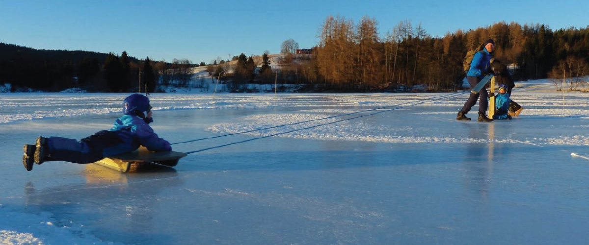 Barn på kjelke på iskarusell