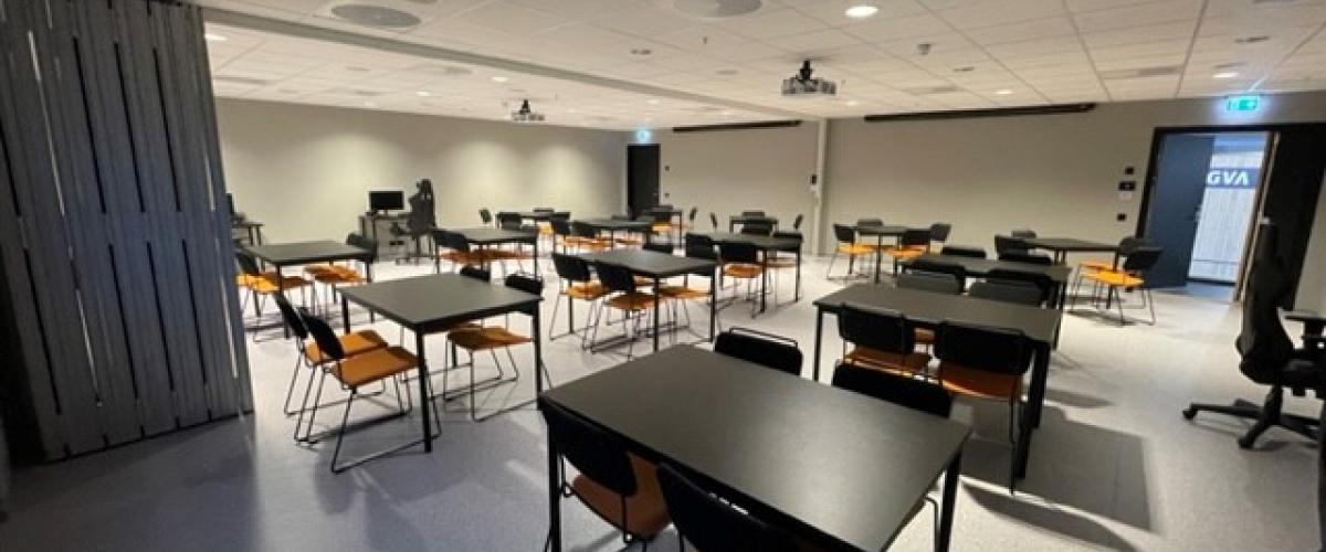 Bord og stoler oppsatt i rommet med navn Barkeriet 2. 