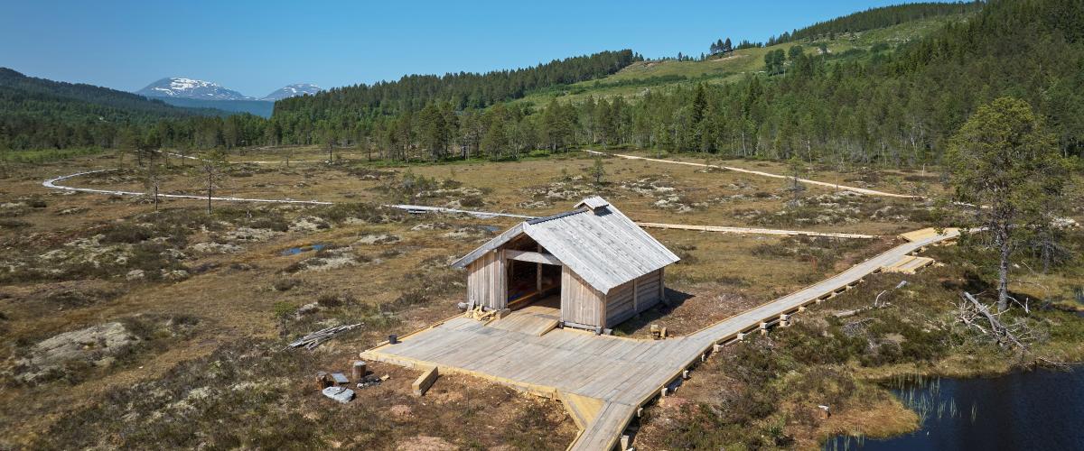 Stor tømmerbu ved Lomtjønna, med rampe og bålgrue, tilrettelagt for rullestolbrukere