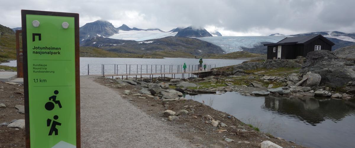 Et skilt står langs grusvegen og informerer om stien