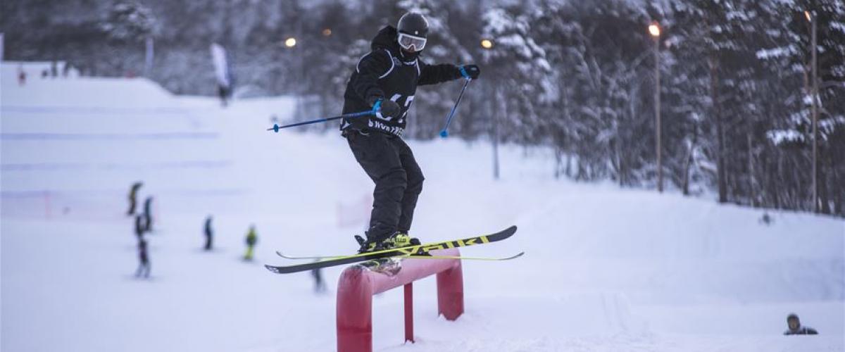 En skikjører som tar en av parkens mange rails. Vedkommende står oppå railen.
