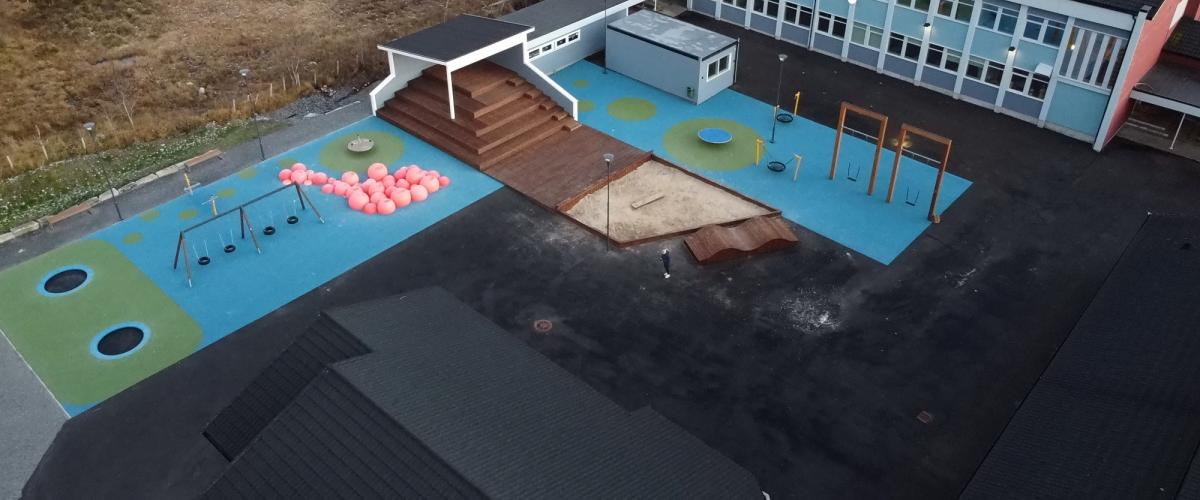 Oversikt over aktivitetspark med disser, trampoliner, sandkasse og amfi.