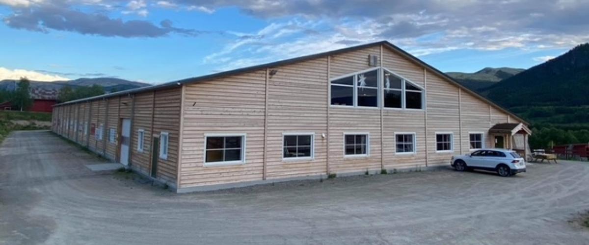 Hovedinngang, god plass til parkering utenfor. Vinduer på kortsida som slipper inn lys mot tribunearealet samt klubbhus.