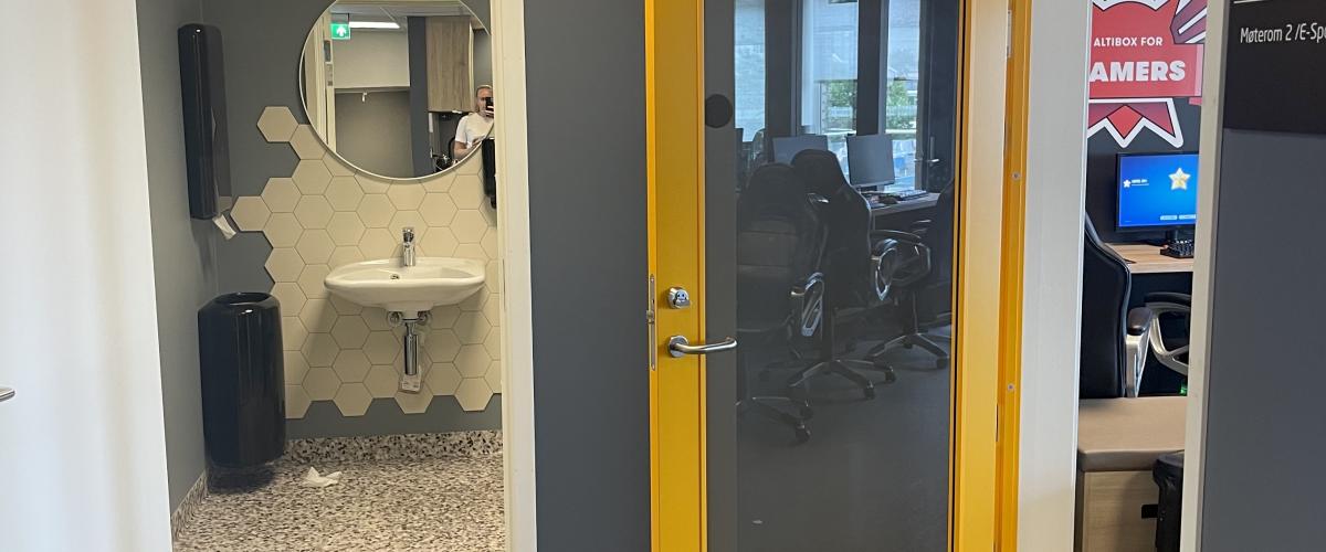 Alle dørene i huset som leder til aktivitet er gule. Foto: Gode idrettsanlegg Bilde av gang med dør inn til HC do og dør til spillrom. Døren inn til spillrommet er gul, dette symboliserer at det er et rom for aktivitet..