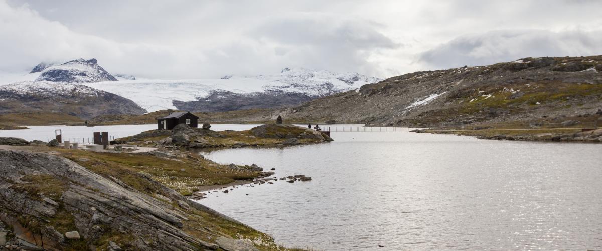 Innfallsporten glir fint inn i terrenget. Du skal se godt etter for å legge merke til at dette ikke er et tradisjonelt, ubesudlet høyfjellsmiljø. Foto: L. A. Sulheim Bildet av brua og rasteplassen på avstand