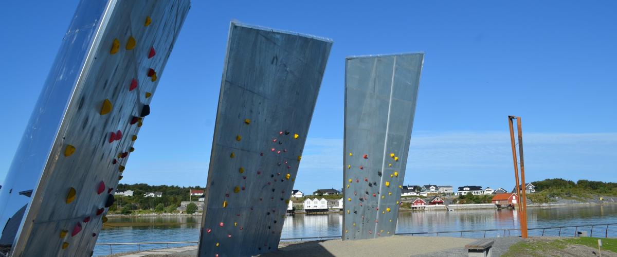 Tre skrå seil av betong og plankpolert stål med klatretak