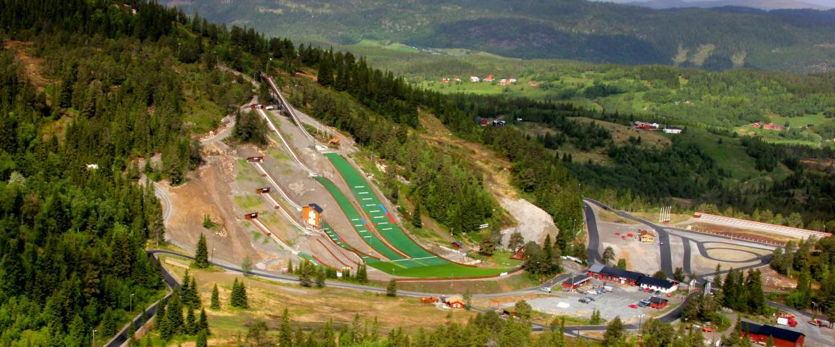 Oversiktsbilde, sommer, med hoppbakker, alpinbakke, rulleskiløyper og standplass
