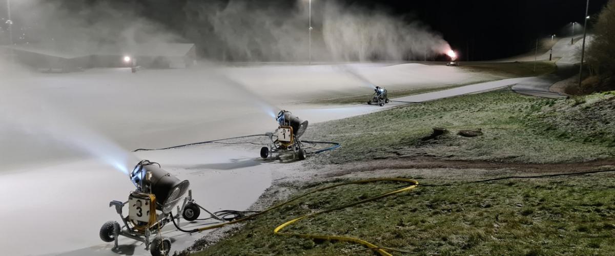 Fire snøkanoner som produserer snø om natten
