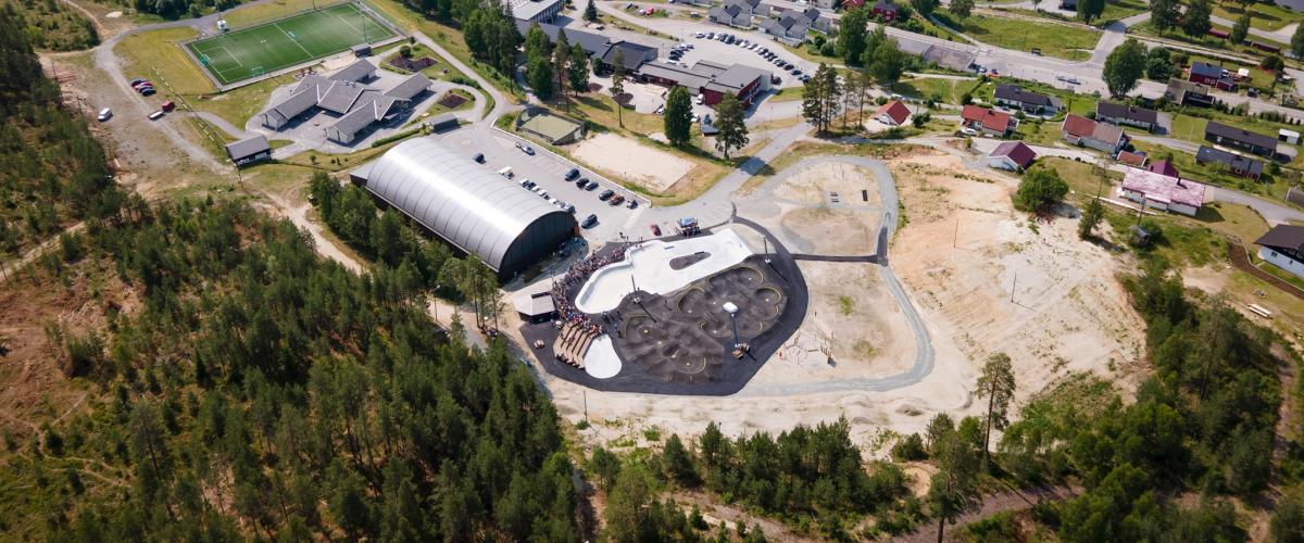 Skole, hall og aktivitetspark sett fra lufta.