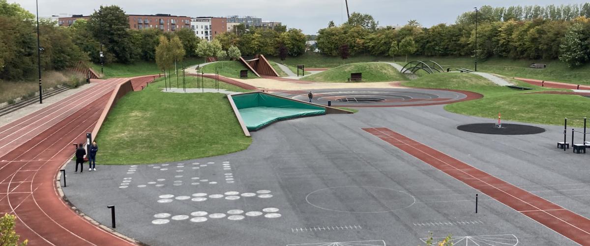 Oversiktsbilde av anlegget der man ser halve løpebanen en løpegrop og andre forhøyete elementer. 
