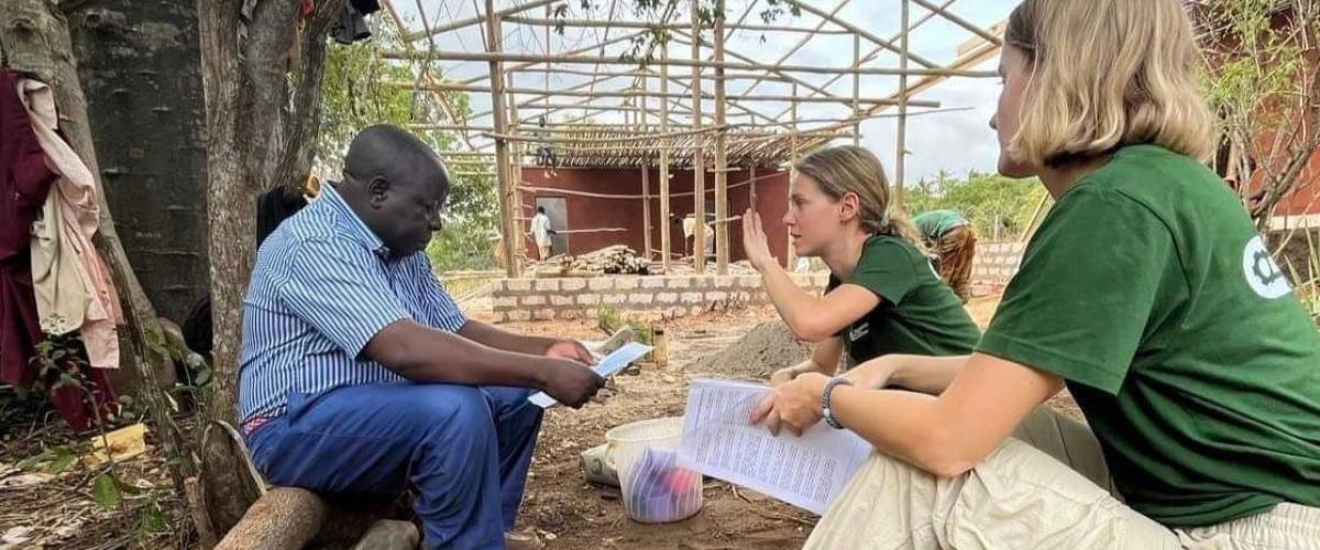 De to studentene snakker med en lokal mann