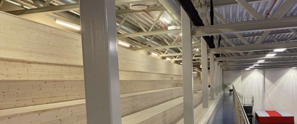 Bilde av hallens tribuner som en kan finne i turnhallen.