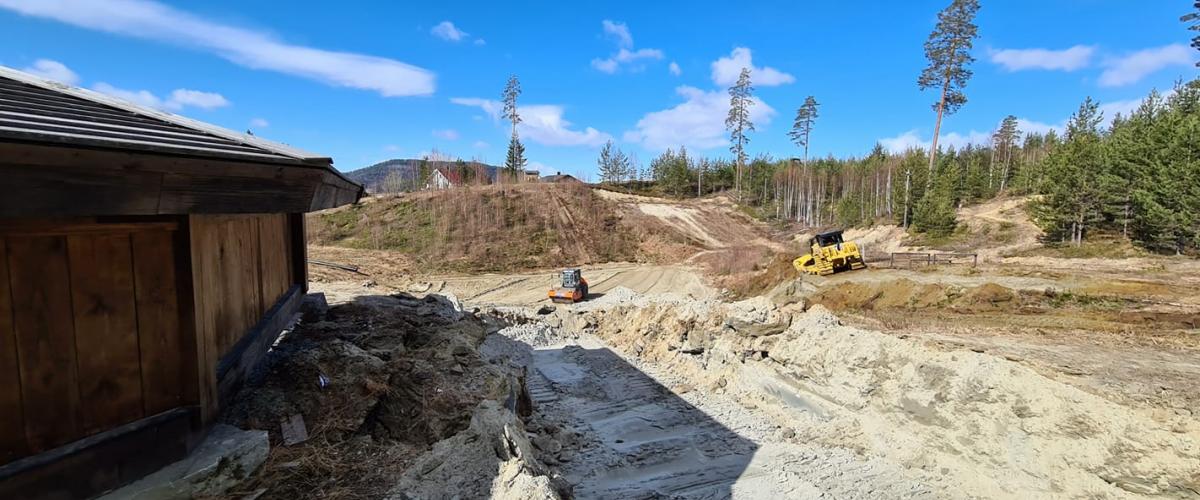 Bulldoser og veivals i gang med å planere området