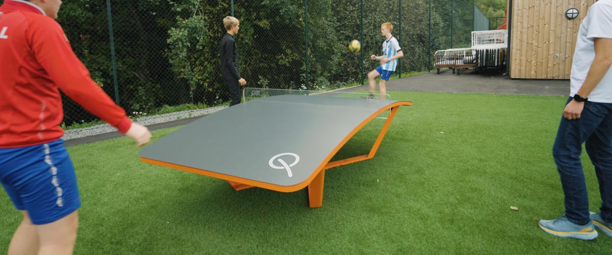 Gutter som spiller på teqballbordet