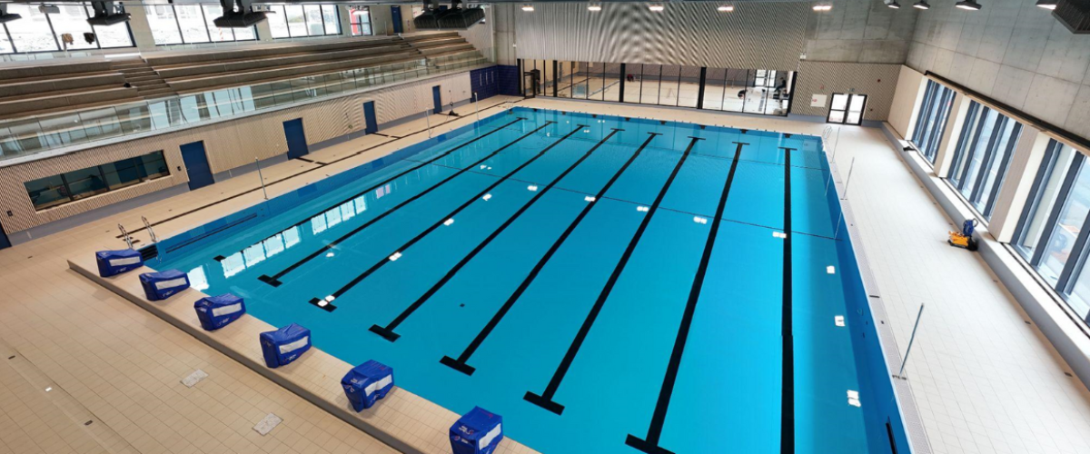 Oversiktsbilde av svømmebaner med tribuner til venstre