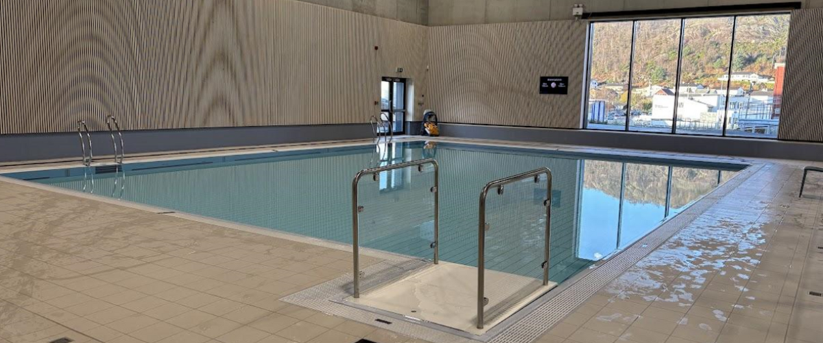 bildet viser et av de mindre bassengene med et stort og opplysende vindu i bakgrunnen