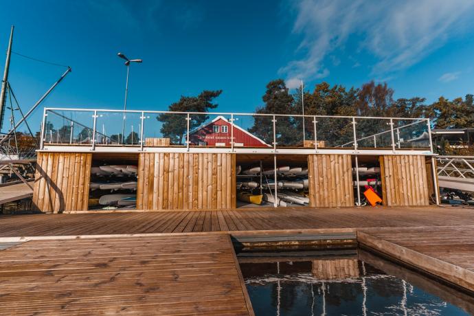 Bilde av den nye brygga ved Strand Kajakklubb, der vi midt i bilder ser at det er laget et hyllesystem som muliggjør  lagring av kajakker nede ved vannkanten. 