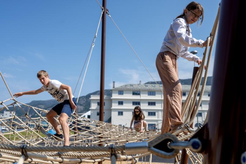 Barn som klatrer i tauklatrestativ. 