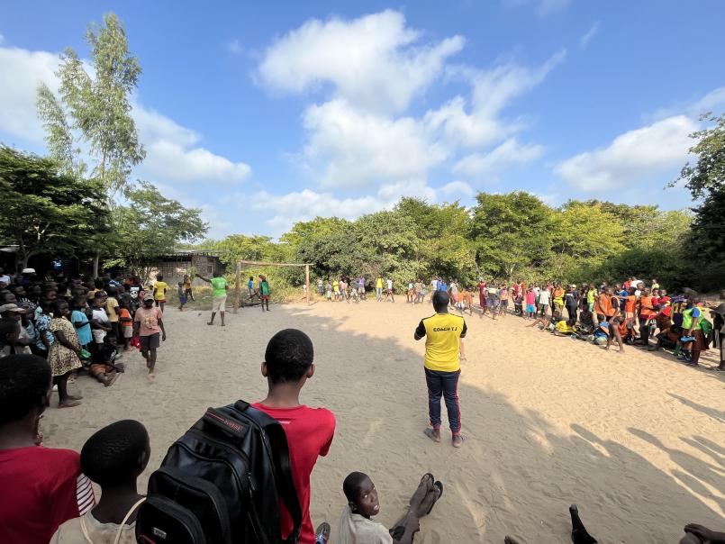 En stor gjeng samlet rundt en bane av sand