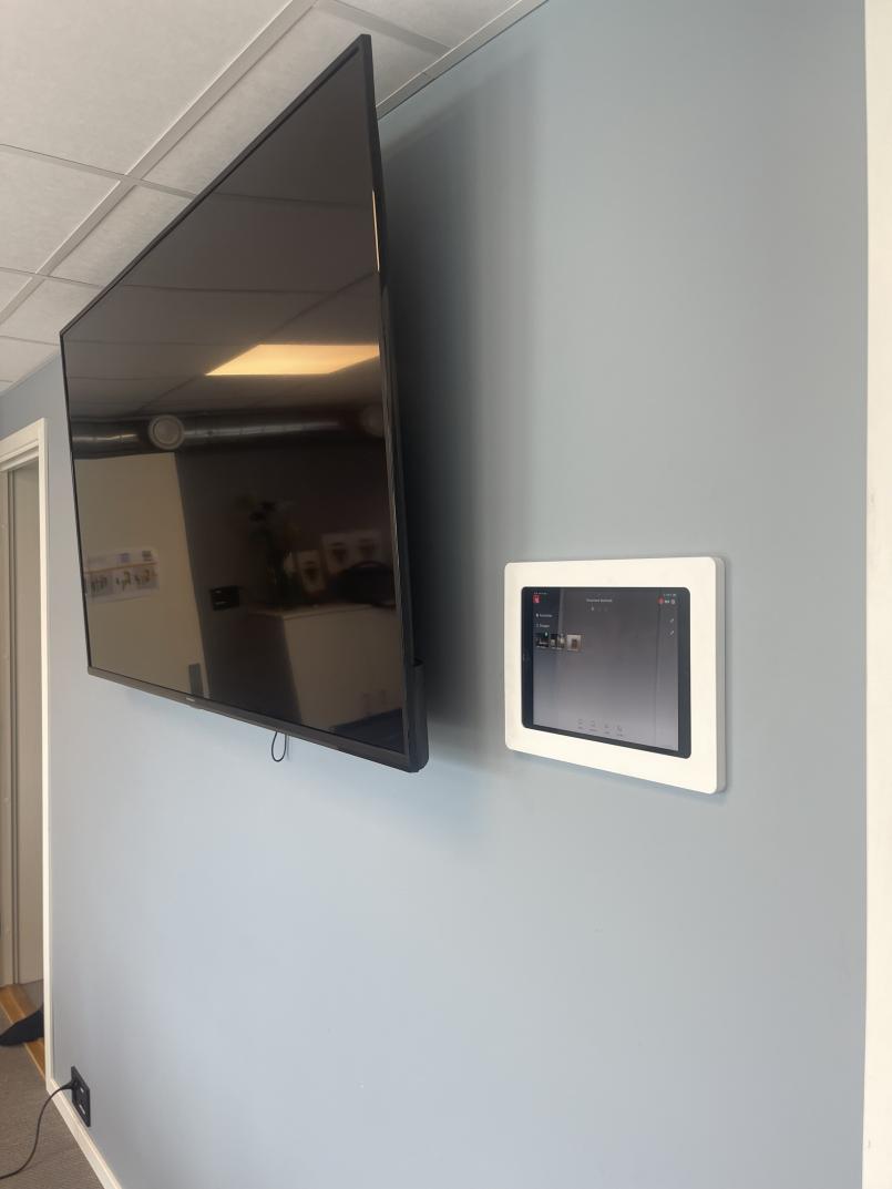 Bilde av tv og en ipad på veggen på ett av møterommene.