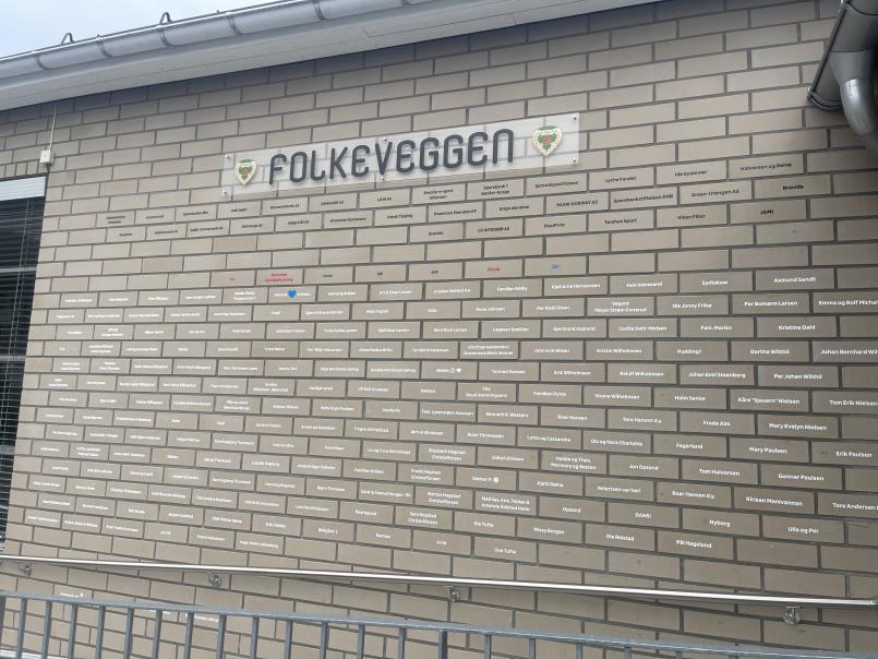 Bilde av folkeveggen, veggen hvor enkeltpersoner eller bedrifter har kjøpt hver sin murstein og klubben har markert murstein med navn. 