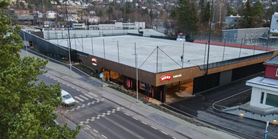 Bilde av anlegget, tatt ovenfra. Viser Meny-butikken som ligger ved siden av en bilvei, og over butikken ligger isflaten. 